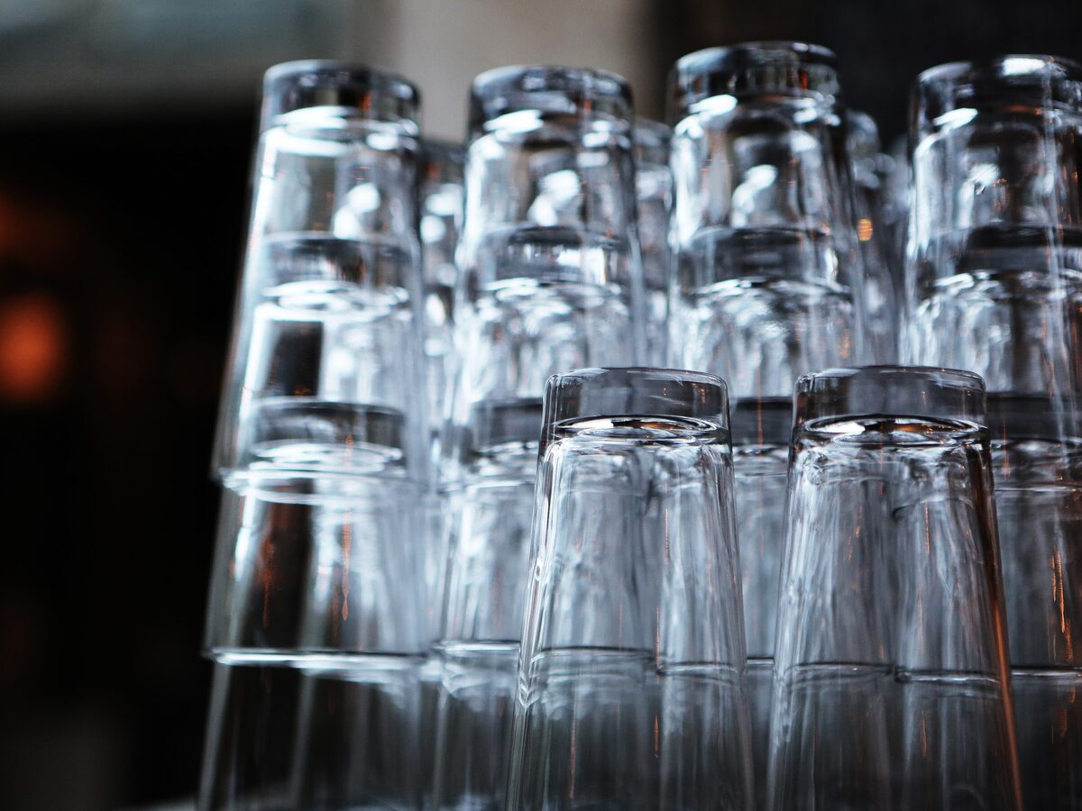 Rows of polished glassware backlit at a bar